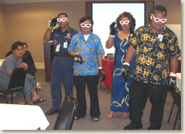 EAD & Associates, LLC carried out an exercise with emergency managers in American Samoa. In this photo, four managers wear special glasses that simulate different visual disabilities to experience what it is like to navigate a reception center or follow recovery instructions with a disability.