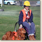 Woman in a wheelchair with service dog dressed in CERT team uniform