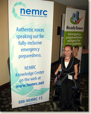 Kelly Rouba, of EAD, with the National Emergency Management Resource banner at the enABLED in Emergencies conference in Philadelphia, PA