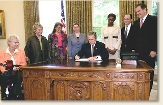 Elizabeth A. Davis (fourth from left) joins Homeland Security Secretary Tom Ridge and others in the Oval Office as President Bush signs Executive Order 13347: Individuals With Disabilities in Emergency Preparedness
